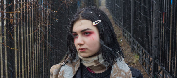 Young woman with eyeshadow standing in snow