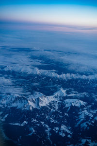 Aerial view of sea and snowcapped mountain against sky