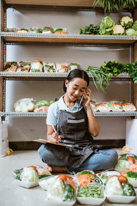 Portrait of young woman sitting at market