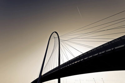Low angle view of silhouette margaret hunt hill bridge against clear sky during sunset