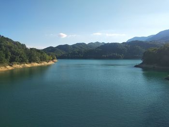 Scenic view of lake by mountains against sky