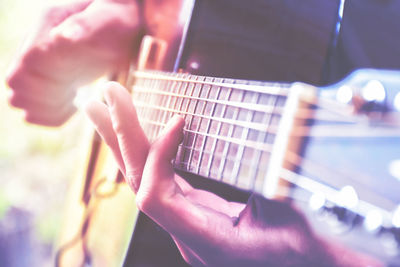 Midsection of man playing guitar