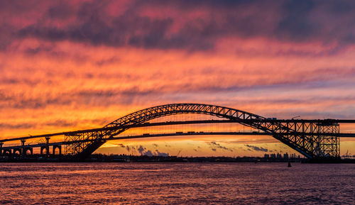 View of bridge over sea against cloudy sky