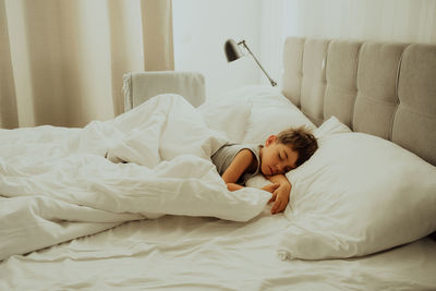 Woman sleeping on bed at home