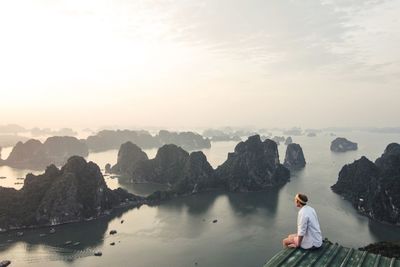 High angle view of man sitting at observation point by river