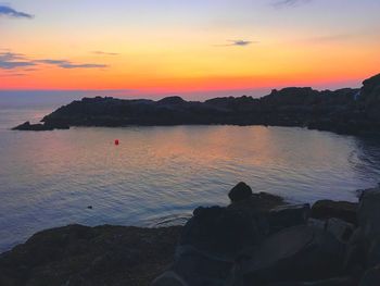 Scenic view of sea against orange sky