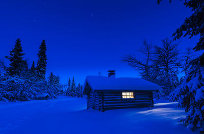 Illuminated log house at night