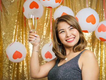Portrait of smiling young woman holding balloons