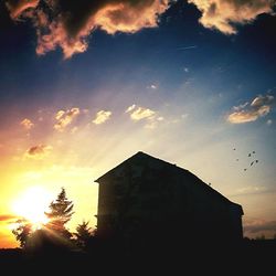 Low angle view of built structure against sunset sky