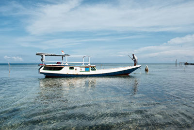 Boat moored in sea against sky