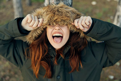Smiling woman wearing fur hat standing outdoors