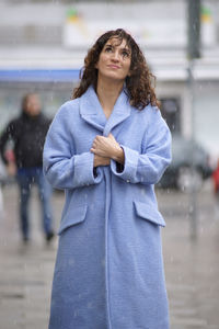 Woman in coat standing on road during winter