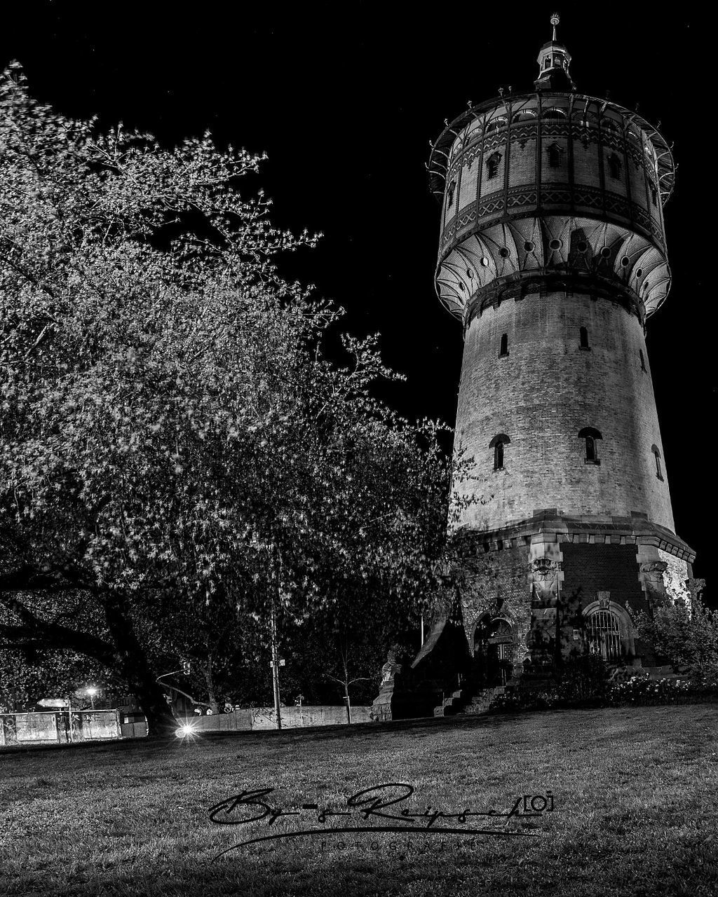 LOW ANGLE VIEW OF LIGHTHOUSE AMIDST TREES AND BUILDINGS