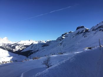 Scenic view of snowcapped mountains against blue sky