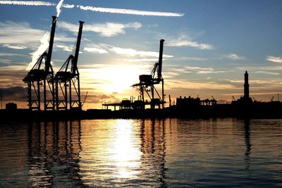 Silhouette boats in sea against sky during sunset