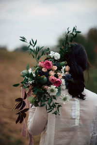Rear view of woman holding flower bouquet