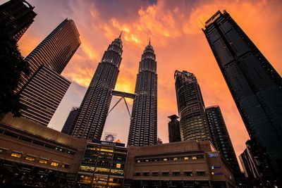 Low angle view of illuminated buildings against sky during sunset