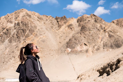 Woman looking at mountains against sky