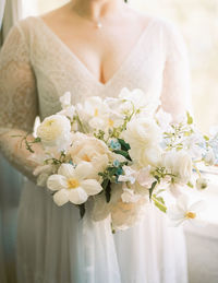 Midsection of bride holding bouquet