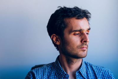 Close-up of mid adult man against blue background