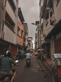 Vehicles on road amidst buildings in city