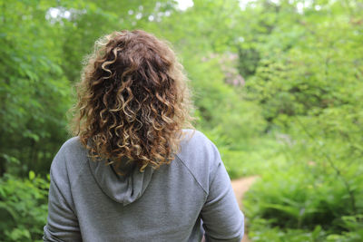 Rear view of woman against trees