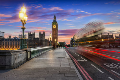 Light trails on westminster bridge with big ben in background during sunset