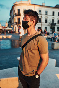 Young man wearing mask standing in city