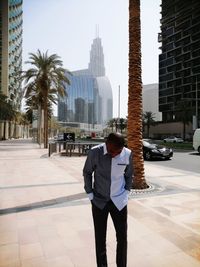 Full length of man standing by modern buildings in city