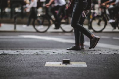 Low section of woman riding bicycle on road