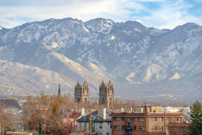 Aerial view of townscape and mountains against sky