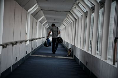 Rear view of man walking in corridor. end of the trip.