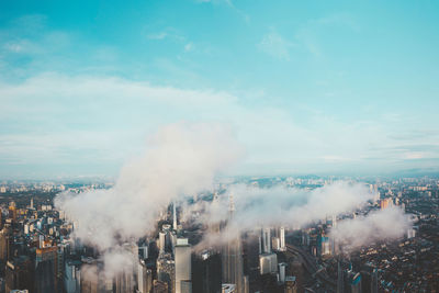 Smoke emitting from factory against sky