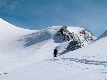 Person skiing on snowcapped mountain against sky