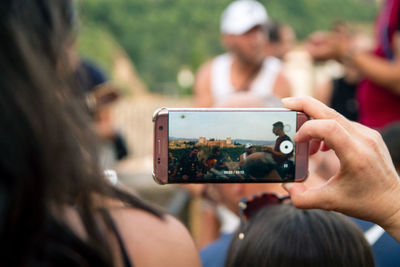 Midsection of woman photographing with mobile phone