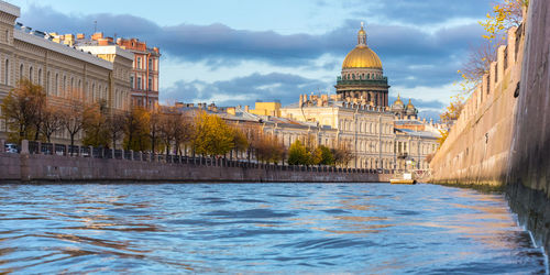 River amidst buildings in city against sky