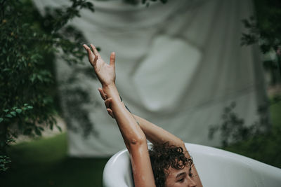 Young woman sitting in bathtub outdoors