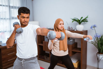 Portrait of young woman exercising in gym