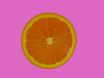 Close-up of lemon slice against pink background