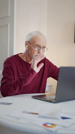 Young woman using laptop at desk in office