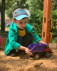 Boy playing with toy on sand