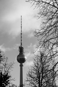 Low angle view of communications tower against cloudy sky