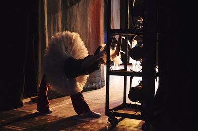 Full length of woman stretching at backstage