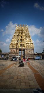 Group of people outside temple against sky