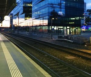 Railroad tracks against sky at night