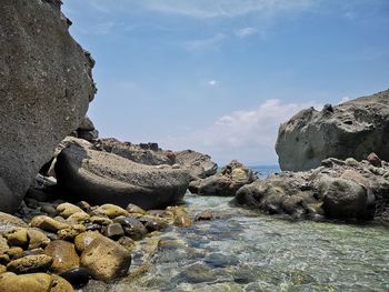 Rocks on beach against sky
