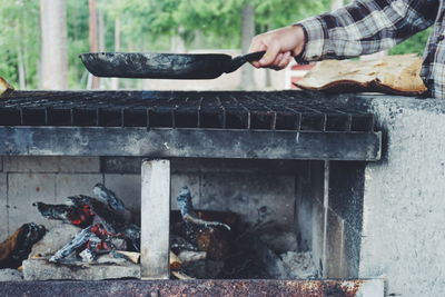 Cropped hand of man preparing food on stove