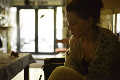 Close-up of woman sitting on chair at home