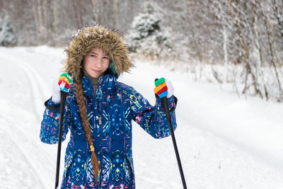 Portrait of woman standing on snow covered land