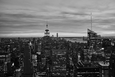 High angle view of city buildings against cloudy sky